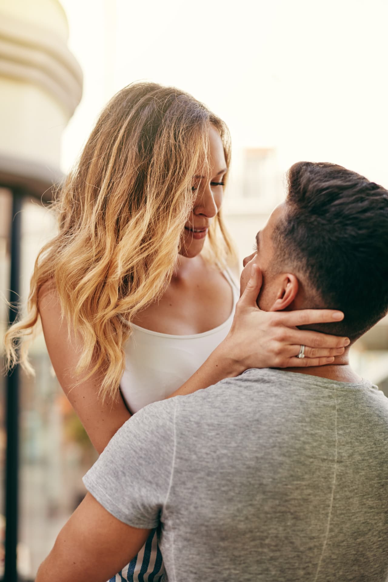 Couple embracing on a sunlit balcony