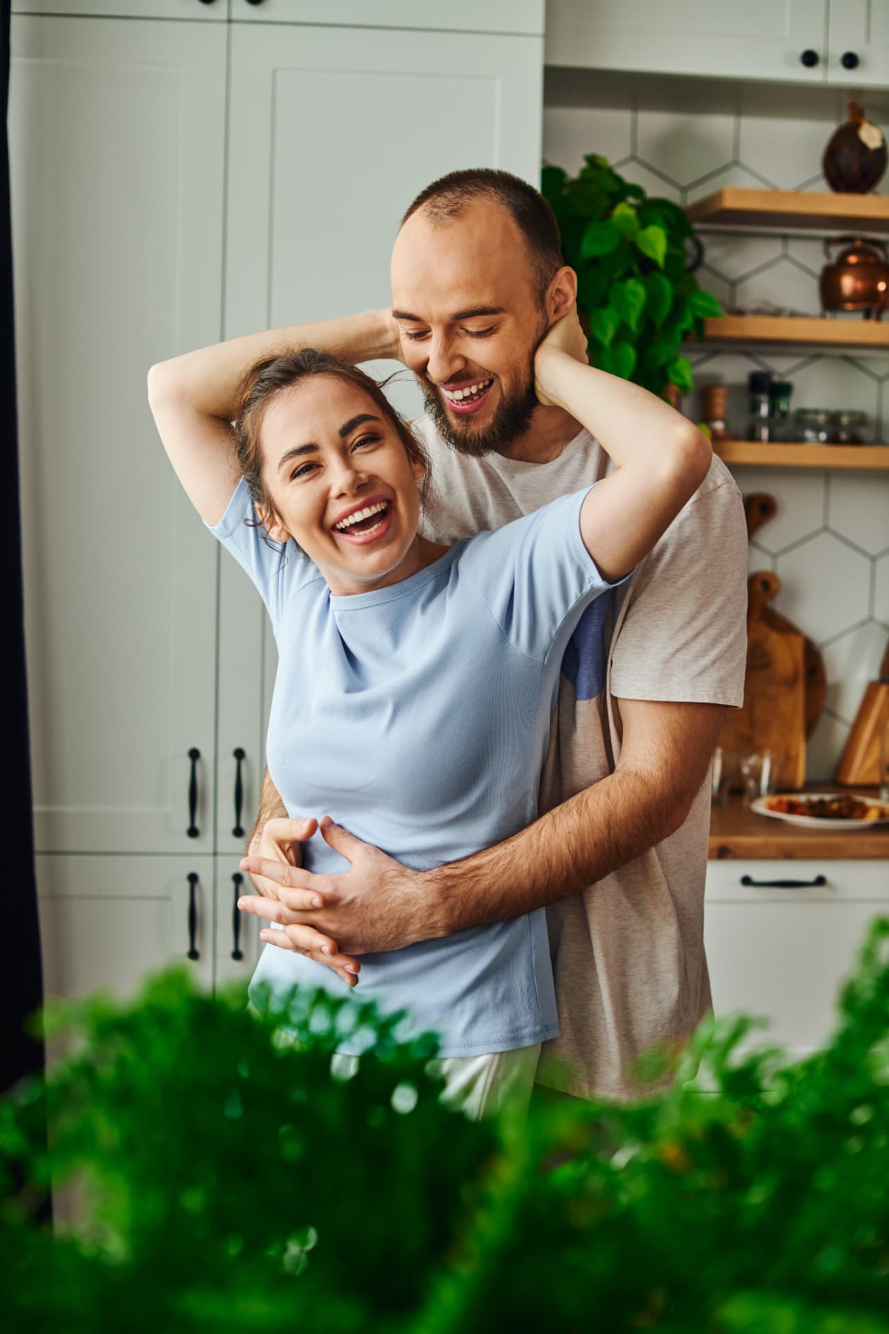 Couple laughing together in a bright kitchen