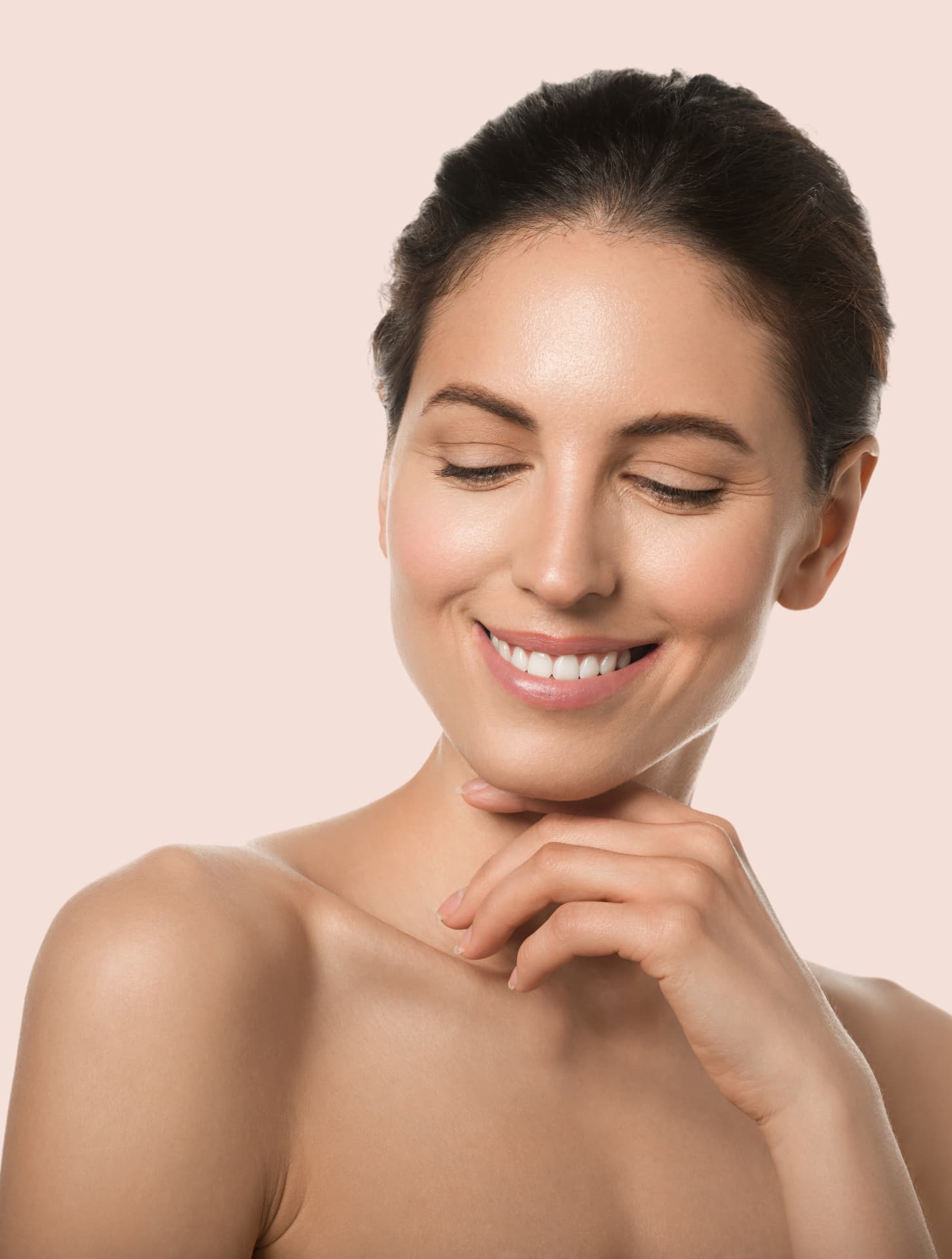 Smiling woman with smooth, even skin resting her hand on her chin