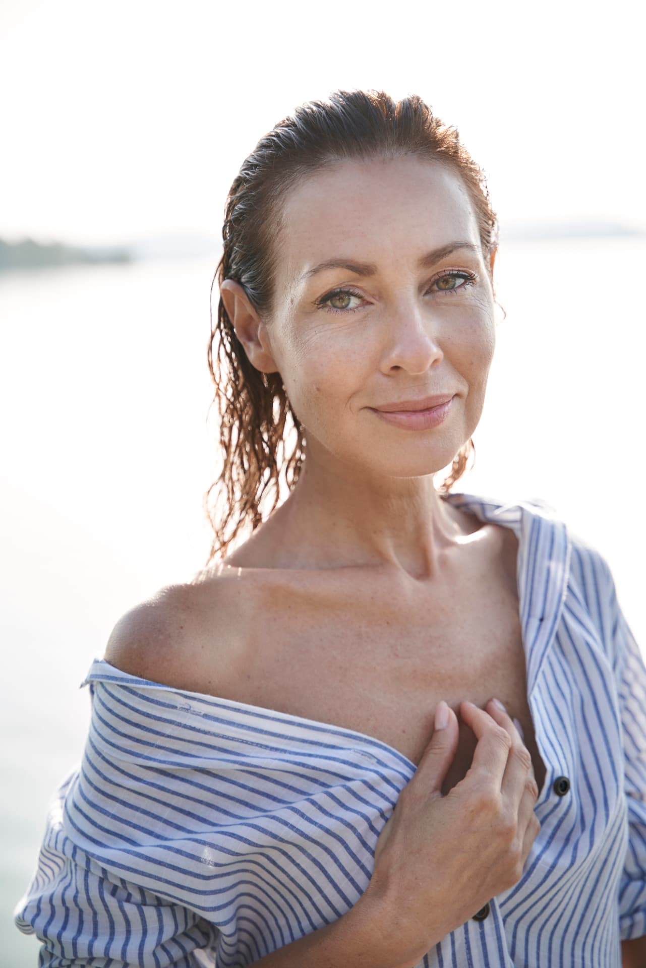 Woman by the coast in soft morning light