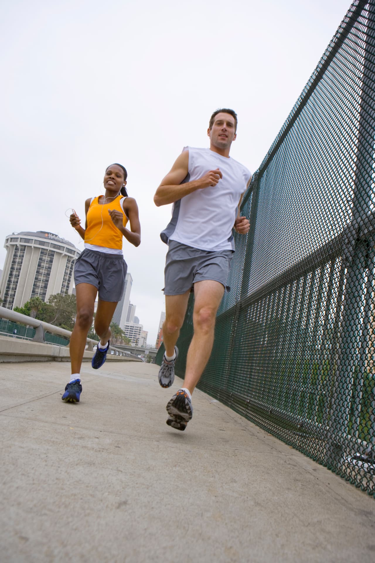 Two runners jogging together along a city walkway