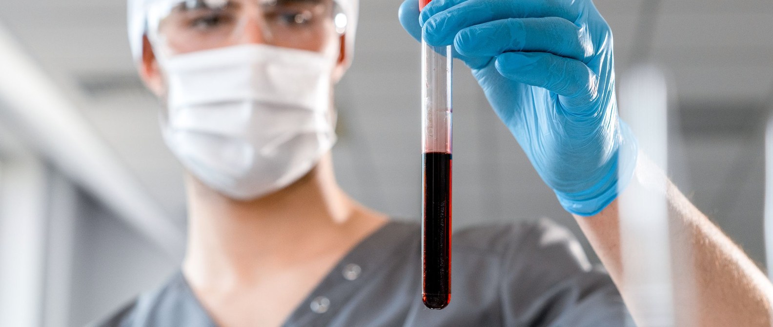 Clinician examining a blood sample in a bright laboratory